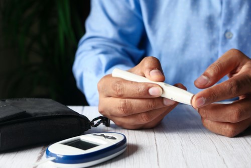 An employee pricking his finger to test his blood sugar during his diabetes management program.